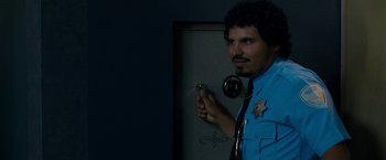 Movie still from “Observe and Report” (2009), directed by Jody Hill – A man in a police uniform holding a gun; Medium shot, Over the shoulder angle