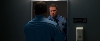 Movie still from “Observe and Report” (2009), directed by Jody Hill – A police officer looking at himself in the mirror; Close Up shot, Over the shoulder angle