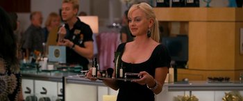 Movie still from “Observe and Report” (2009), directed by Jody Hill – A beautiful blonde woman holding a tray of cosmetics; Medium shot, Over the shoulder angle