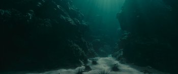 Movie still from “Oceans” (2009), directed by Jacques Cluzaud – The sun shines through the water of a rocky underwater cave; Extreme Wide shot, High angle