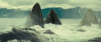 Movie still from “Oceans” (2009), directed by Jacques Cluzaud – A couple of large rocks in the water; Extreme Wide shot, Low angle