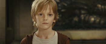 Movie still from “Oceans” (2009), directed by Jacques Cluzaud – A young boy with blonde hair and a white t - shirt; Close Up shot, Low angle