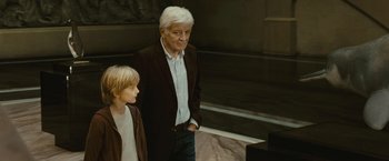 Movie still from “Oceans” (2009), directed by Jacques Cluzaud – An older man and a young boy standing next to each other; Medium shot, Over the shoulder angle
