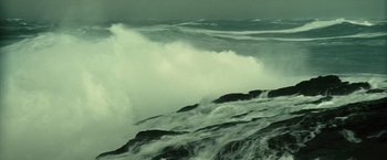 Movie still from “Oceans” (2009), directed by Jacques Cluzaud – A large body of water with waves crashing on the shore; Extreme Wide shot, High angle