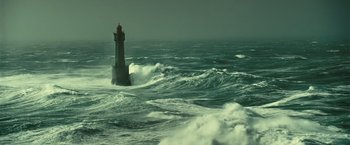 Movie still from “Oceans” (2009), directed by Jacques Cluzaud – A lighthouse in the middle of the ocean with waves crashing around it; Extreme Wide shot, High angle