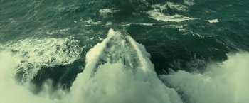 Movie still from “Oceans” (2009), directed by Jacques Cluzaud – A view of the back of a boat in the water; Extreme Wide shot, Overhead angle