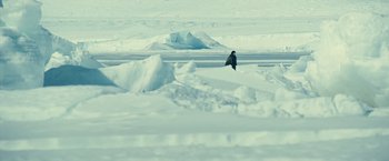 Movie still from “Oceans” (2009), directed by Jacques Cluzaud – A person riding a snowboard on top of a snow covered slope; Extreme Wide shot, High angle