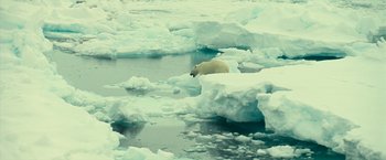 Movie still from “Oceans” (2009), directed by Jacques Cluzaud – A polar bear walking through the ice on the water; Extreme Wide shot, High angle