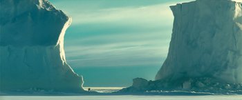 Movie still from “Oceans” (2009), directed by Jacques Cluzaud – A person standing on top of an iceberg in the middle of the ocean; Extreme Wide shot, Low angle