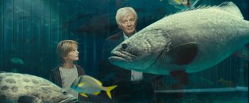 Movie still from “Oceans” (2009), directed by Jacques Cluzaud – A man and a woman looking at a fish; Medium shot, Low angle