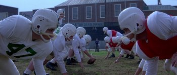 Movie still from “October Sky” (1999), directed by Joe Johnston – A group of young football players in a field; Wide shot, High angle