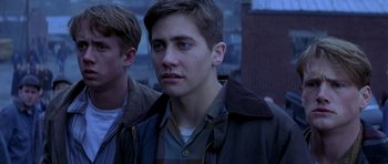 Movie still from “October Sky” (1999), directed by Joe Johnston – A young man in a brown jacket looking at the camera; Close Up shot, Over the shoulder angle