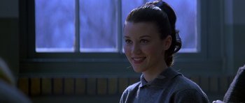 Movie still from “October Sky” (1999), directed by Joe Johnston – A woman with a ponytail smiling for the camera; Close Up shot, Over the shoulder angle