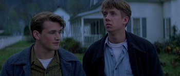 Movie still from “October Sky” (1999), directed by Joe Johnston – Two young men standing next to each other in front of a house; Close Up shot, Low angle