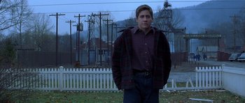 Movie still from “October Sky” (1999), directed by Joe Johnston – A young man standing in front of power lines; Medium shot, Low angle