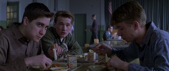 Movie still from “October Sky” (1999), directed by Joe Johnston – A group of people sitting at a table eating food; Medium shot, Over the shoulder angle