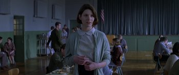 Movie still from “October Sky” (1999), directed by Joe Johnston – A woman standing in front of a group of people; Medium shot, Over the shoulder angle