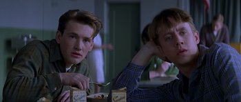 Movie still from “October Sky” (1999), directed by Joe Johnston – Two young men sitting at a dinner table; Close Up shot, Low angle