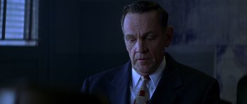 Movie still from “October Sky” (1999), directed by Joe Johnston – A man in a suit and tie looking down; Close Up shot, Low angle