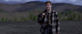 Movie still from “October Sky” (1999), directed by Joe Johnston – A young man in a plaid shirt and a jacket; Medium shot, High angle