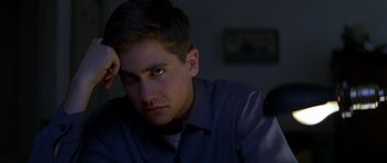 Movie still from “October Sky” (1999), directed by Joe Johnston – A man sitting in front of a tv in a dark room; Close Up shot, High angle