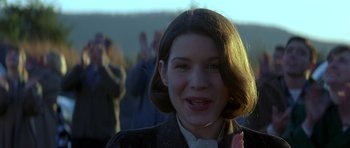 Movie still from “October Sky” (1999), directed by Joe Johnston – A young girl smiling for the camera with a crowd in the background; Close Up shot, Low angle