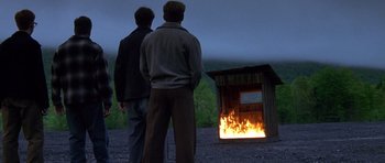 Movie still from “October Sky” (1999), directed by Joe Johnston – Two men standing in front of a fire pit at night; Wide shot, Low angle