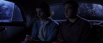 Movie still from “October Sky” (1999), directed by Joe Johnston – A man and a woman sitting in the back of a car at night; Medium shot, Low angle