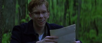 Movie still from “October Sky” (1999), directed by Joe Johnston – A man with glasses is holding a piece of paper; Close Up shot, High angle