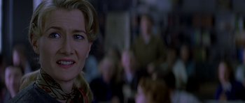 Movie still from “October Sky” (1999), directed by Joe Johnston – A woman's face in front of a group of people; Close Up shot, Over the shoulder angle