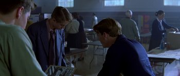 Movie still from “October Sky” (1999), directed by Joe Johnston – Two people looking at a book in a room; Medium shot, Over the shoulder angle