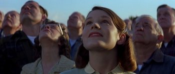 Movie still from “October Sky” (1999), directed by Joe Johnston – A woman looking up at the sky with her eyes wide open; Close Up shot, Low angle