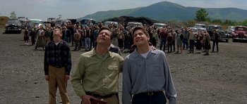 Movie still from “October Sky” (1999), directed by Joe Johnston – A couple of men standing next to each other on top of a field; Medium shot, Low angle
