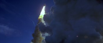Movie still from “October Sky” (1999), directed by Joe Johnston – A rocket is flying through the air with smoke coming out of it; Extreme Wide shot, Low angle
