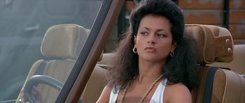 Movie still from “Octopussy” (1983), directed by John Glen – A woman sitting in the driver's seat of a car; Close Up shot, Low angle