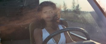 Movie still from “Octopussy” (1983), directed by John Glen – A woman sitting in the driver's seat of a car; Close Up shot, Low angle
