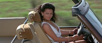 Movie still from “Octopussy” (1983), directed by John Glen – A woman sitting in the driver's seat of a car; Close Up shot, High angle