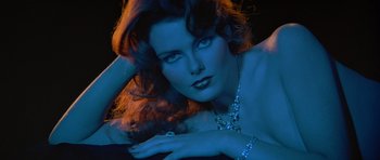 Movie still from “Octopussy” (1983), directed by John Glen – A beautiful woman laying on the ground in the dark; Close Up shot, Low angle