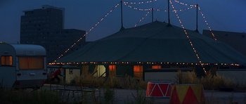 Movie still from “Octopussy” (1983), directed by John Glen – A tent with lights hanging from it's roof at night; Extreme Wide shot, Low angle
