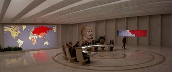 Movie still from “Octopussy” (1983), directed by John Glen – A group of people sitting at a table in front of a painting; Extreme Wide shot, Low angle