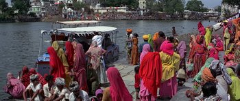 Movie still from “Octopussy” (1983), directed by John Glen – A group of people standing next to a body of water; Wide shot, High angle