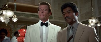 Movie still from “Octopussy” (1983), directed by John Glen – A man in a suit and tie next to another man in a suit and tie; Medium shot, Low angle