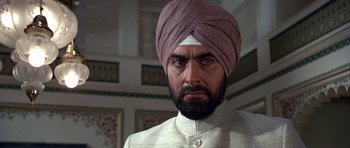 Movie still from “Octopussy” (1983), directed by John Glen – A person wearing a turban; Close Up shot, Low angle
