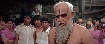 Movie still from “Octopussy” (1983), directed by John Glen – An old man with long white hair and a long white beard; Close Up shot, Low angle