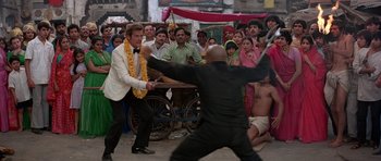 Movie still from “Octopussy” (1983), directed by John Glen – Two men are fighting in front of a crowd of onlookers; Wide shot, High angle