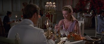 Movie still from “Octopussy” (1983), directed by John Glen – A man and a woman sitting at a dinner table; Medium shot, Over the shoulder angle