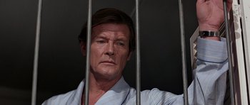 Movie still from “Octopussy” (1983), directed by John Glen – A person behind a fence; Close Up shot, High angle