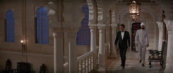 Movie still from “Octopussy” (1983), directed by John Glen – A man in a tuxedo walking down a staircase; Wide shot, Low angle