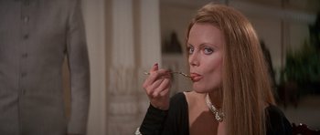 Movie still from “Octopussy” (1983), directed by John Glen – A beautiful woman holding a twig in her mouth; Close Up shot, Over the shoulder angle