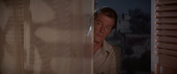 Movie still from “Octopussy” (1983), directed by John Glen – A person looking out a window; Close Up shot, Over the shoulder angle